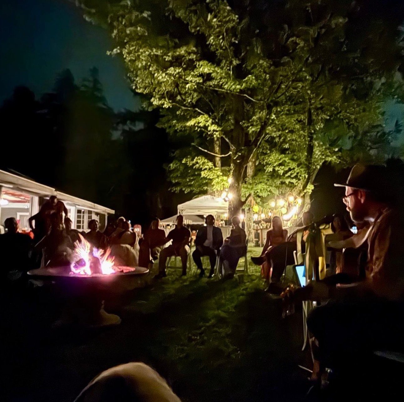 Guests gathered around a fire while Dan performs